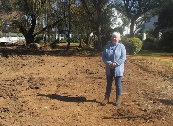 Fairland Estate resident Arlene Mania stands beside the stalled Fairland gabions project, where work has come to a halt despite earlier assurances that contractors would return. Photo: Waydon Jacobs