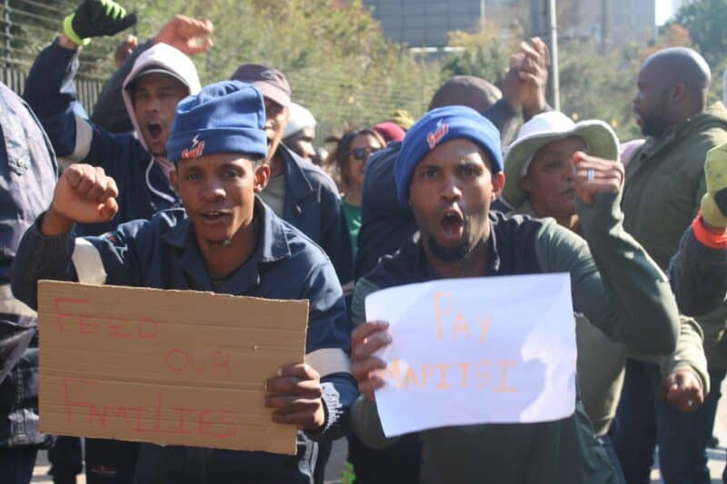 Protesters display placards reading ‘Feed Our Families’ and ‘Pay Mapitsi’ as contractors demand payment after alleging they have gone unpaid for more than three months on August 7, 2026. Photo: Waydon Jacobs