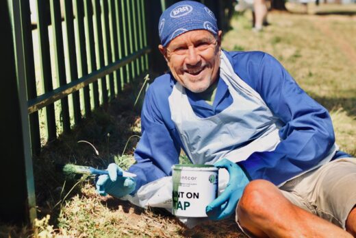 Gary Boast happily forms part of the community members painting the fence. Photo: Neo Phashe