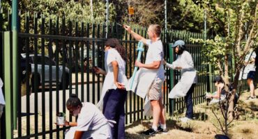 Community members happily paint the fence. Photo: Neo Phashe