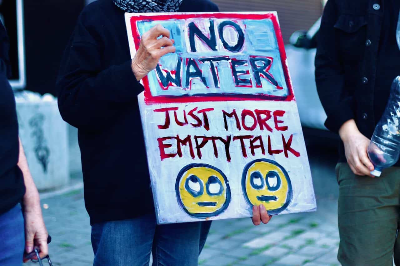 A Melville protester holds up a board that reads, ‘No water just empty promises’, on September 14, 2026 in Melville. Photo: Neo Phashe