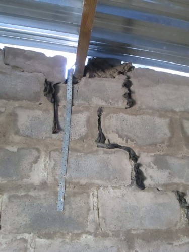 Sindy Sibiya uses pieces of cloth to fill the cracks on her walls like this one.