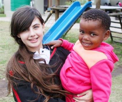 Jessica Broom enjoys her time spent playing with one of the orphans at the Nkobongo Resource Centre after dropping off the hampers.
