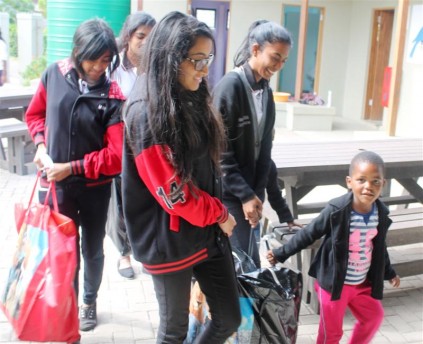 The pupils, (back) Maya Pillay, Demishka Valaitham, (front) Nikaila Naidoo and Jenisha Govender take the hampers to the Nkobongo Resource Centre.