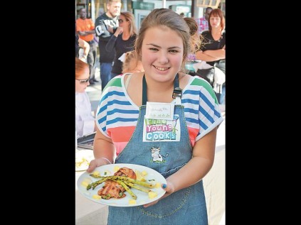 Contestant Abigail van der Linde off to show her completed dish to the judges.