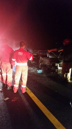 Paramedics examine the shell of a vehicle. Photo: IPSS Medical Rescue
