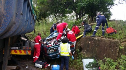 Paramedics try to get the occupants out of the crushed car. Photo: IPSS Medical Rescue