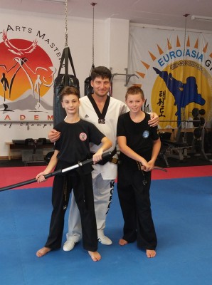 The two young Taekwondo black belts are Daniel Grachev and Jack Maidman with Guk-Jae Sabum Nim Grachev in the middle.