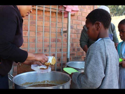Children receiving a hot meal as part of the school's government sponsored daily nutrition programme.
