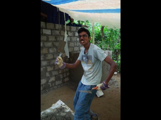 Sherav Beekum laying cement on the toilet the group built for a disabled man in Vietnam.