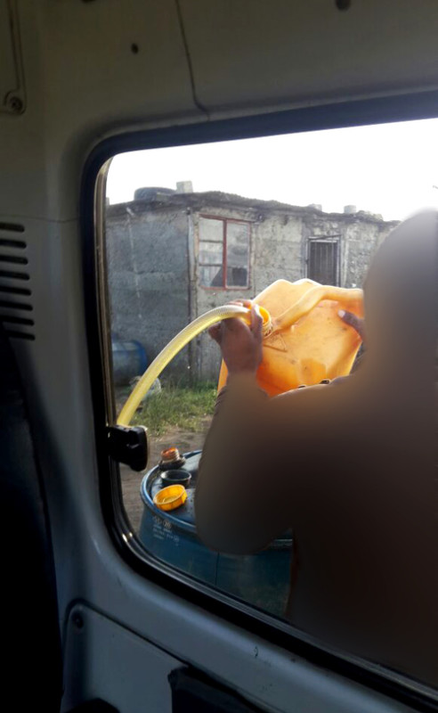 A taxi driver fills up his tank at an illegal fuel depot in Isithebe where fuel is sold at below market value.