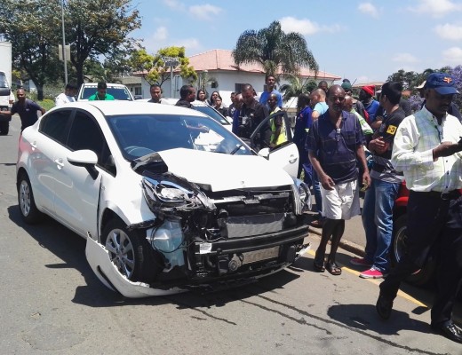 Onlookers regard the vehicle used by the suspects in their attempt to escape.