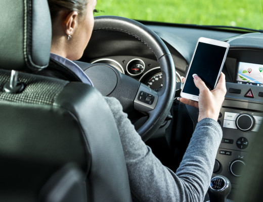 35352188 - young female driver using touch screen smartphone and gps navigation in a car.