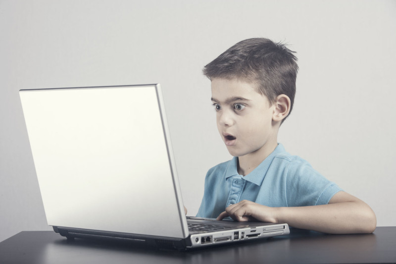 50011515 - boy reacts while using a laptop.