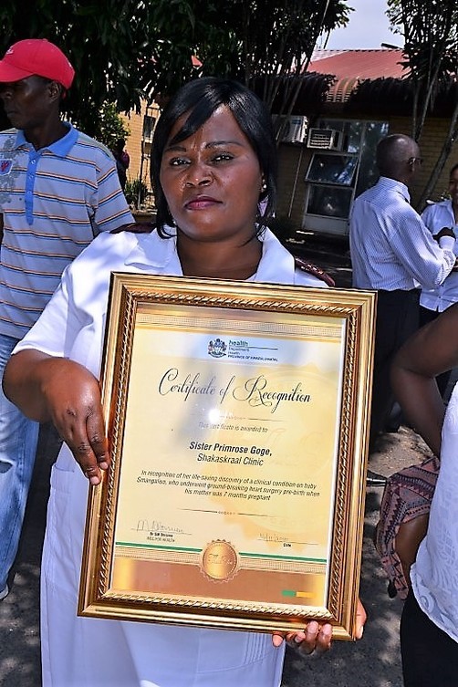 Shakaskraal Clinic Nurse Primrose Goge holding up her certificate from KZN Health MEC Sibusiso Dhlomo