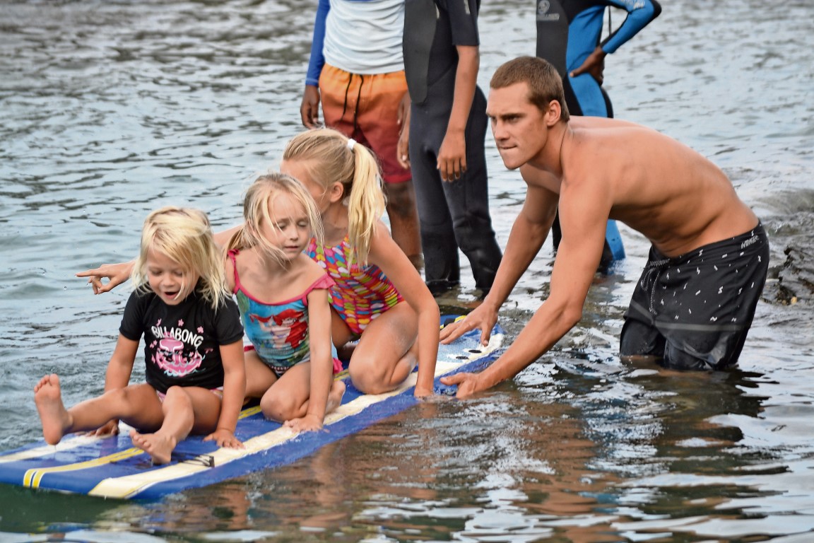 Justin Sykes helps some of the girls get used to the surfboard.