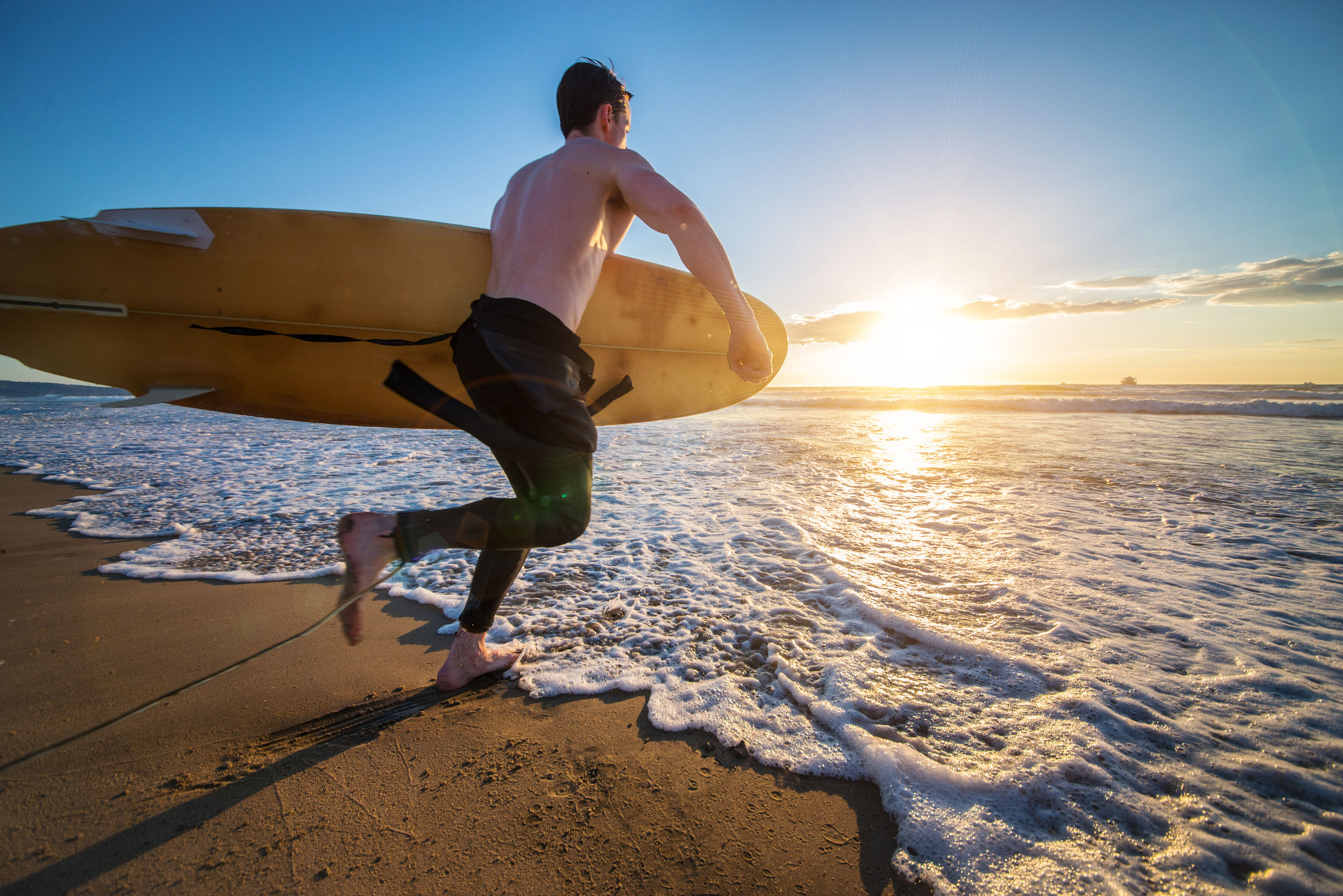 Surfer running into the water