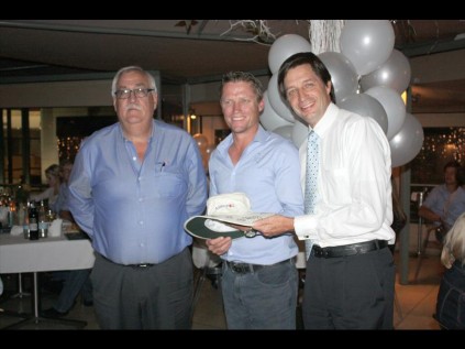 The coach for TuksCricket’s first team, Pierre de Bruyn (center), presents a special signed cricket hat to Gert Wessels, Executive Director at Assupol (left) and Rudi Schmidt, CEO of the Assupol Group. Photo: Koos Venter