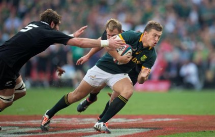 Handré Pollard, jong 20-jarige losskakel van die Blou Bulle en die Springbokke, was Saterdag op Ellispark een van die Springbokke se grootste sterre. Hy het die All Blacks in die eerste helfte geskud met twee puik drieë, waarmee hy – veral met die eerste poging – hul verdediging aan repe geskeur het. Hier glip die briljante jong Pollard verby die grypende hande van twee verdedigers op pad na sy eerste drie. Foto: GB Jordaan 