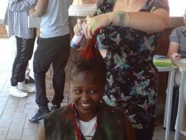 Christine le Roux (teacher) spraying Sakile Mketi.
