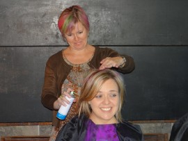 The teachers in action. Belinda Cloete spraying Stephanie Vermaak's hair.