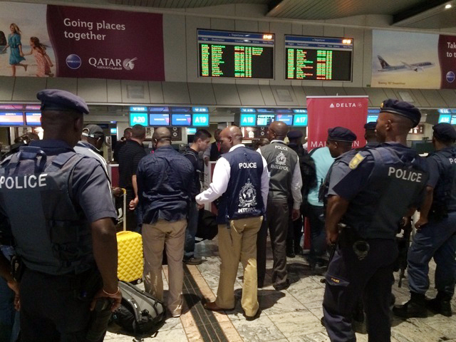 Members of Interpol escorting the suspects to their flight to the USA. Photo: Supplied