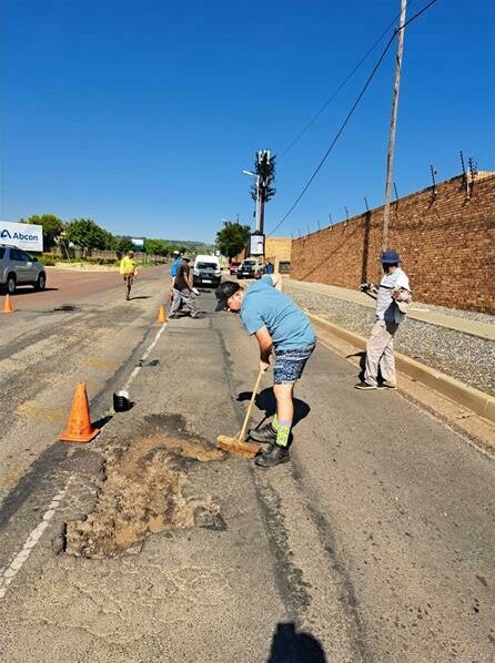 Residents, ward councillor and business patch potholes in Silverlakes Road