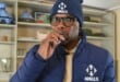 Man in branded blue clothing enjoying a lozenge indoors.