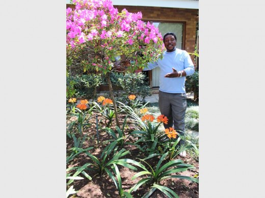 Morgan Petlho stands amidst his blooming garden.