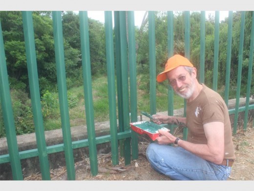 Resident Chris Herold paints the fence.