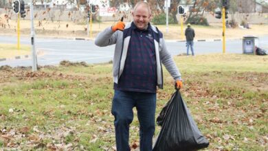 Brendon Gouws collects a bag full of rubbish. Photo: Nicholas Zaal