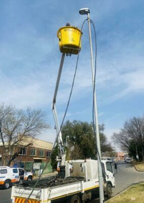 Crane truck parks near the street light as City Power officials cut illegal connections. Photo: Simon Majadibodu