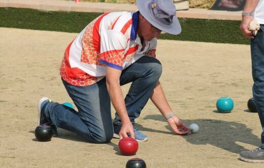Gavin Rose measures which team has the closest bowl to the pin. Photo: Nicholas Zaal
