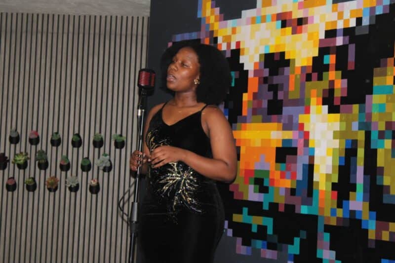  A performer takes to the vintage microphone during the Swiss Hotel School's Great Gatsby Gala Dinner, her black gown adding to the evening's elegant atmosphere.Photo: Nkazimulo Ncube