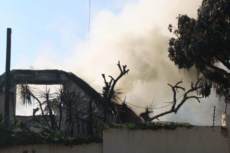 Thick smoke billows from the charred remains of a thatched roof as fire tears through a two-storey home at the corner of Kowie Road and Baleta Avenue in Randpark Ridge. Photo: Nkazimulo Ncube