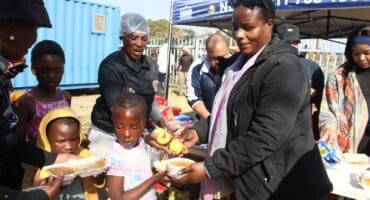 Pretty Ndlovu, an NCTV chief executive officer, gives soup to children in Itsoseng in celebration of Mandela Day. Photo: Mthulisi Lwazi Khuboni