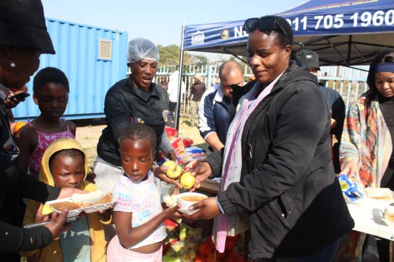 Pretty Ndlovu, an NCTV chief executive officer, gives soup to children in Itsoseng in celebration of Mandela Day. Photo: Mthulisi Lwazi Khuboni