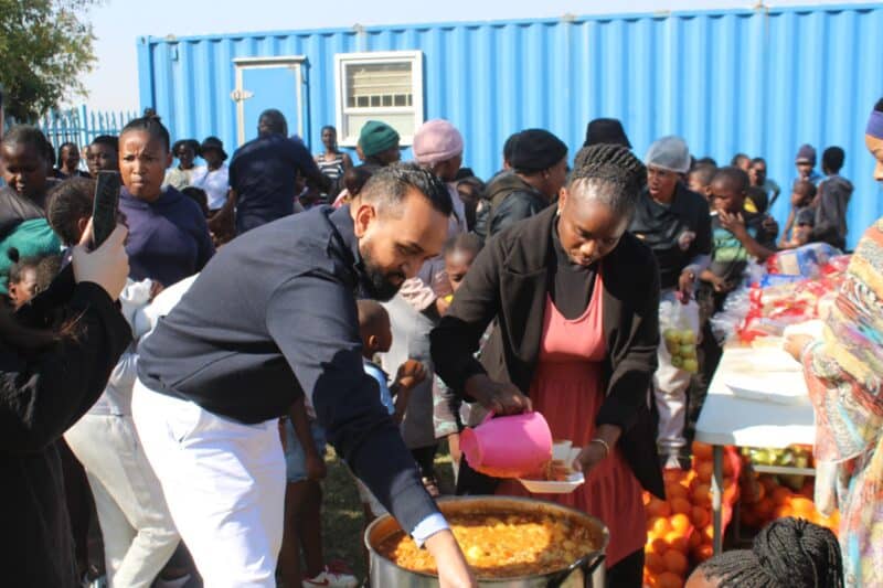 Elton Gorral and Justine Bopape give soup to children in Itsoseng in celebration of Mandela Day. Photo: Mthulisi Lwazi Khuboni