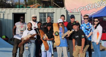 Prize-winning skaters proudly show off their brand-new skateboard decks alongside event organisers and judges. Photo: Nkazimulo Ncube