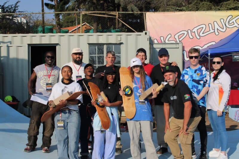 Prize-winning skaters proudly show off their brand-new skateboard decks alongside event organisers and judges. Photo: Nkazimulo Ncube