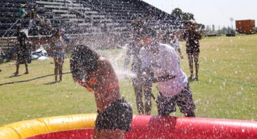 Students get soaked by water spraying over an inflatable paddling pool during outdoor games at the spring day event. Photo: Nkazimulo Ncube