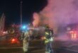 Two firefighters in full protective gear stand near the smouldering vehicle transporter truck on the N1 near Beyers Naudé Drive, as thick smoke rises into the night sky. Photo: Supplied