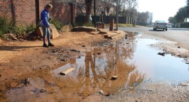 Ward 102 councillor Bea Campbell-Cloete at the troubling leak on Pretoria Road in Ferndale. Photo: Mthulisi Lwazi Khubon