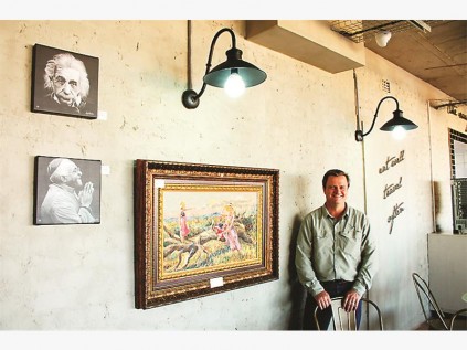 Mnr. Johan van Rensburg (bestuurder, Alzu Petroport) by ’n paar van die kunswerke van plaaslike kunstenaar Danie Smith, wat te koop is.