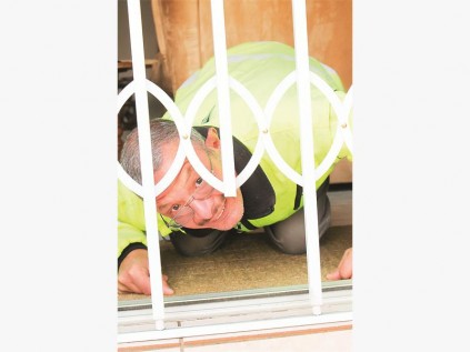 Me. Bell se seun, Hannes, loer deur die gaatjie onder die veiligheidshek waar 'n booswig deurgeklim het om toegang tot die huis te kry. Dié gaatjie is vir die klein hondjie om toegang tot die huis te hê.