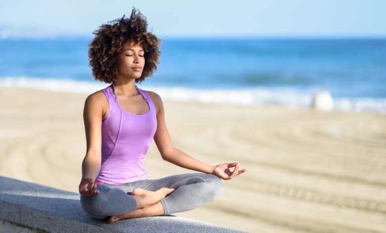 Black,Woman,,Afro,Hairstyle,,Doing,Yoga,Asana,In,The,Beach