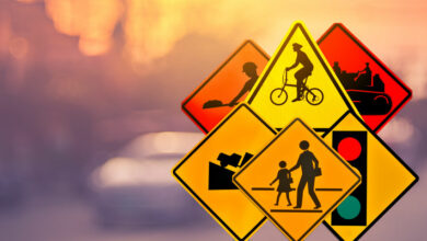 Set of traffic warning sign on blur traffic road with colorful bokeh light abstract background.