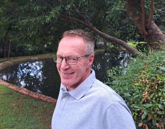 Man with glasses in front of a pool.