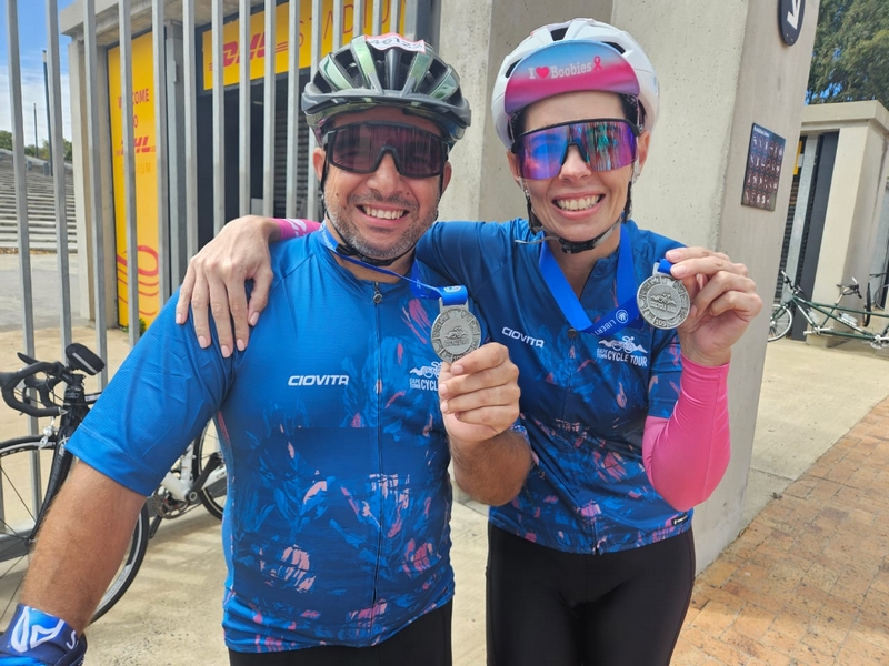 Man and woman showing their medals.