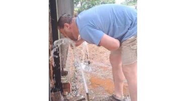 Man drinking water from fountain at his broken water meter